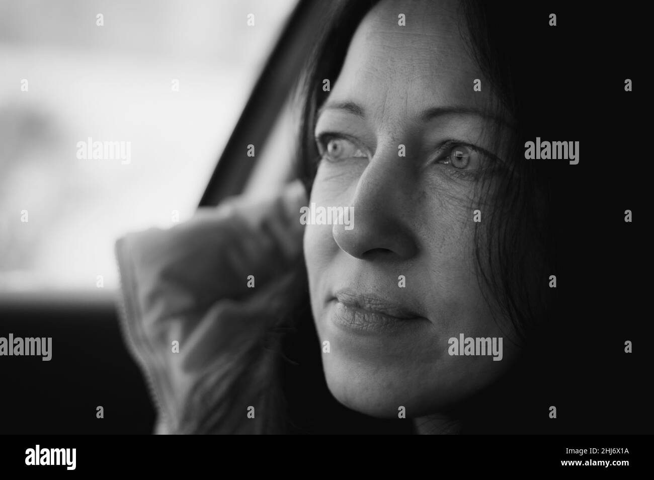 Glückliche Frau, die im Auto sitzt und lächelt. Glückliche Menschen Stockfoto