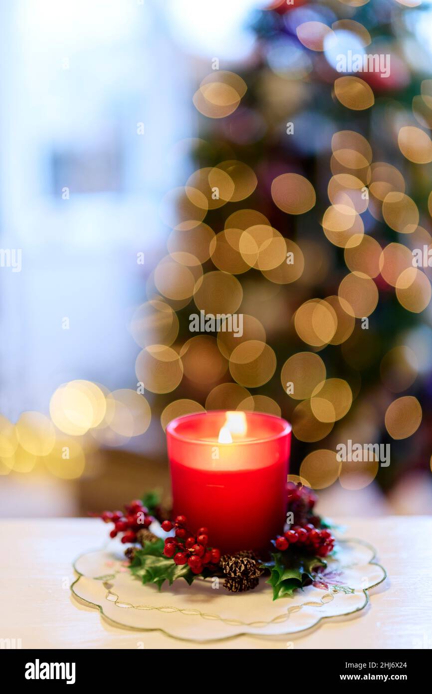 Beleuchtete Kerze vor dem Weihnachtsbaum Stockfoto