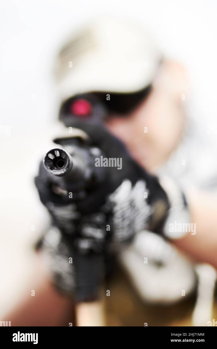 Ein Fass runter. Nahaufnahme selektiver Fokus auf den Lauf einer Waffe, die von einem Soldaten gehalten wird. Stockfoto