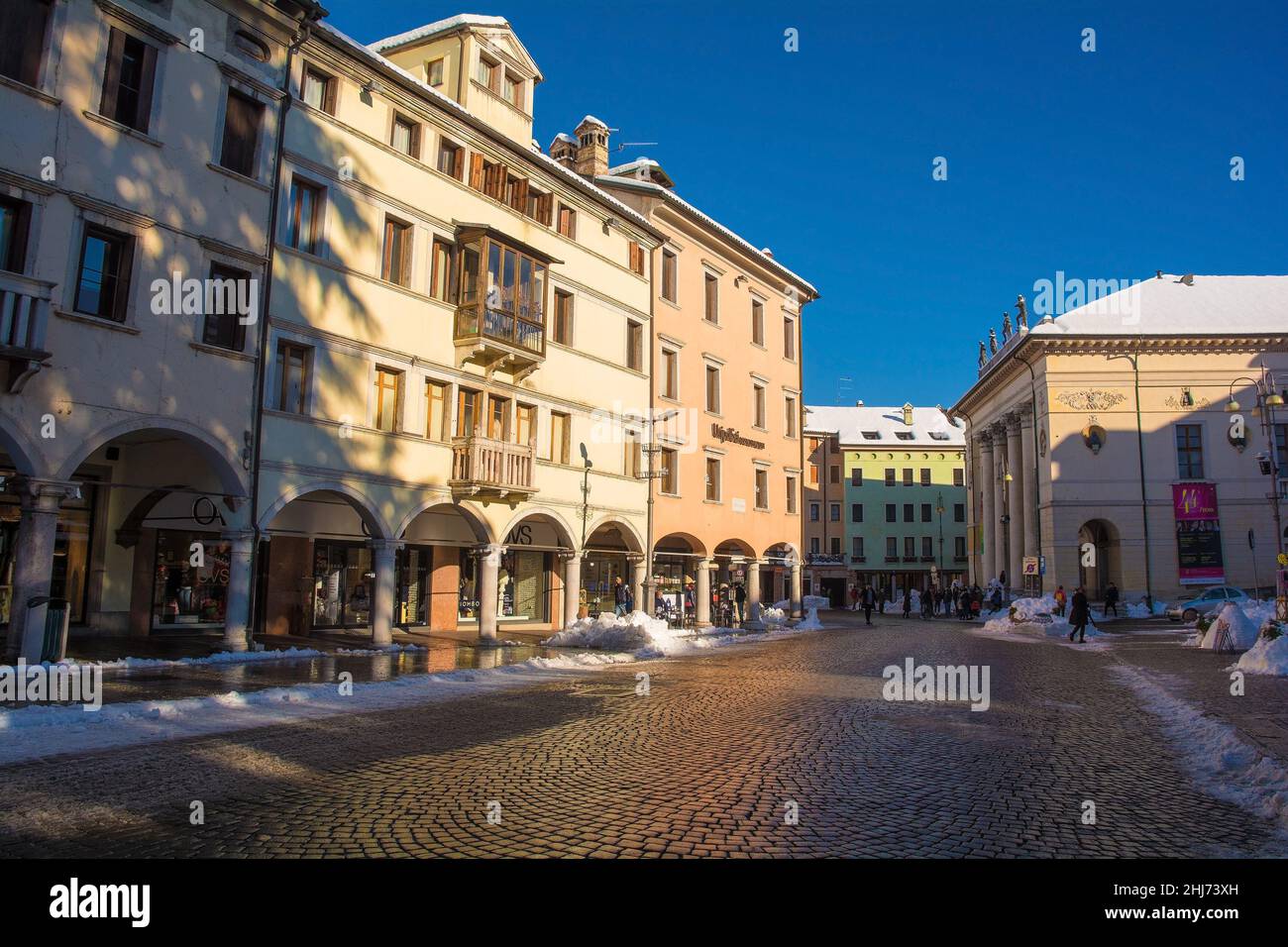 Belluno, Italien - Dez 11 2021. Dezember Schnee in einer historischen Straße in der nordöstlichen italienischen Stadt Belluno, Region Venetien. Auf der Piazza dei Martiri Stockfoto