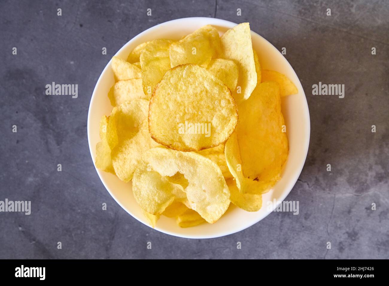 Eine weiße Schüssel mit pommes Frites auf schwarzem Schiefergrund Stockfoto