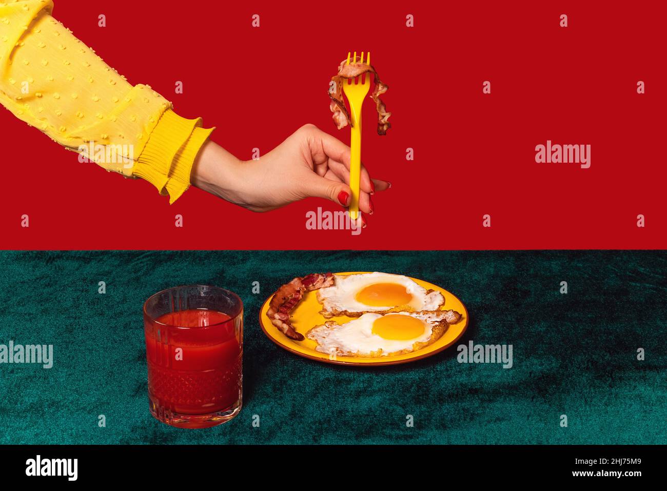 Von Menschenhand schmeckender Speck und Eier auf grünem und rotem Hintergrund. Interieur im Retro-Stil. Food Pop Art Fotografie. Stockfoto