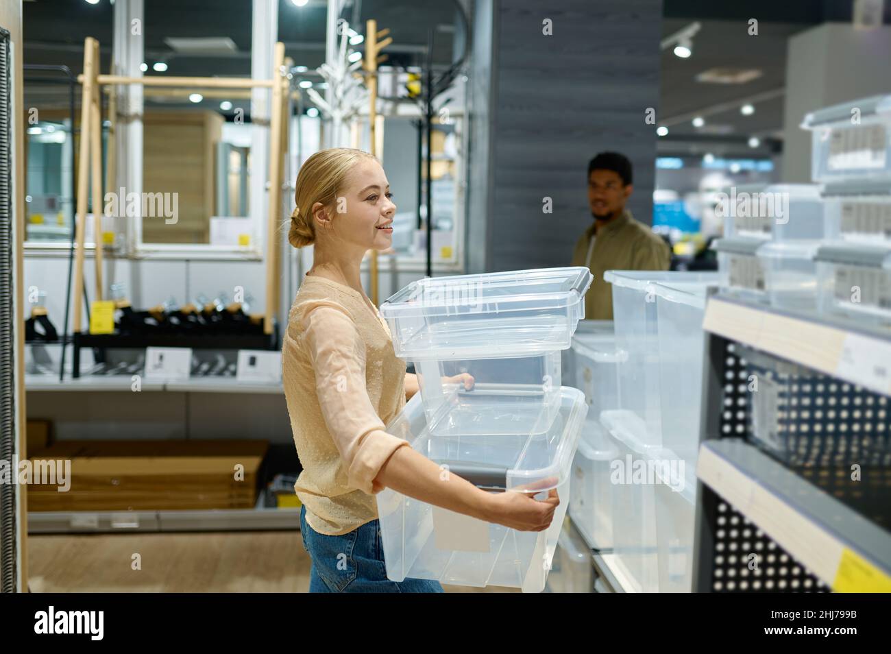 Frau, die im Geschäft Kunststoffbehälter auswählt Stockfoto