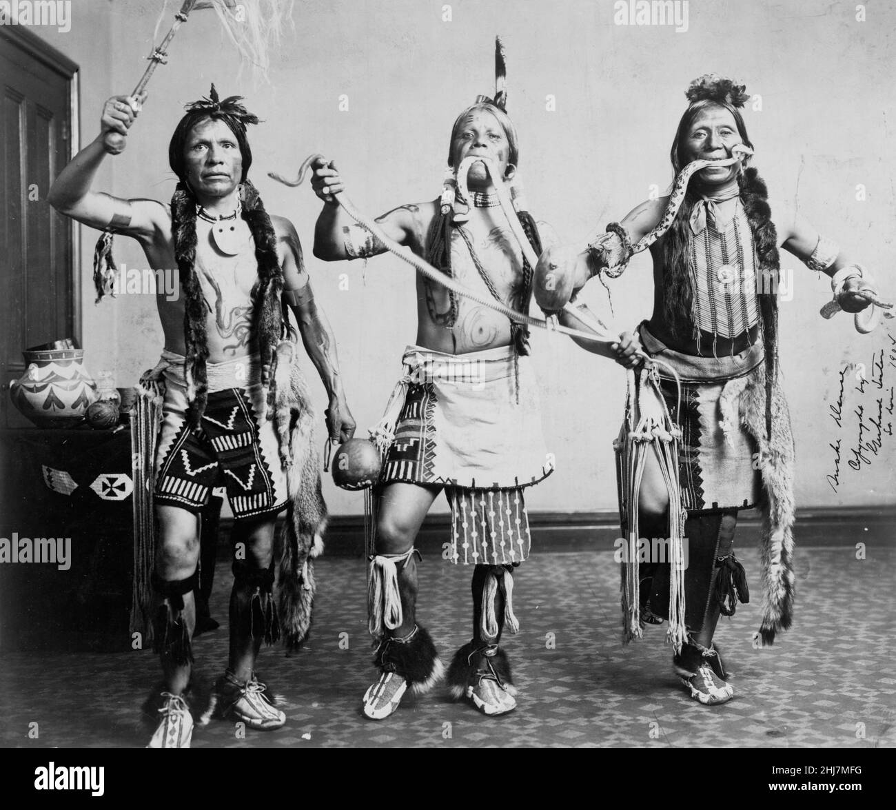 Drei indianische Männer, in traditioneller Kleidung, posierten, als ob sie einen Schlangentanz vorführen würden. Gerhard Sisters, Fotograf. c 1905. Stockfoto