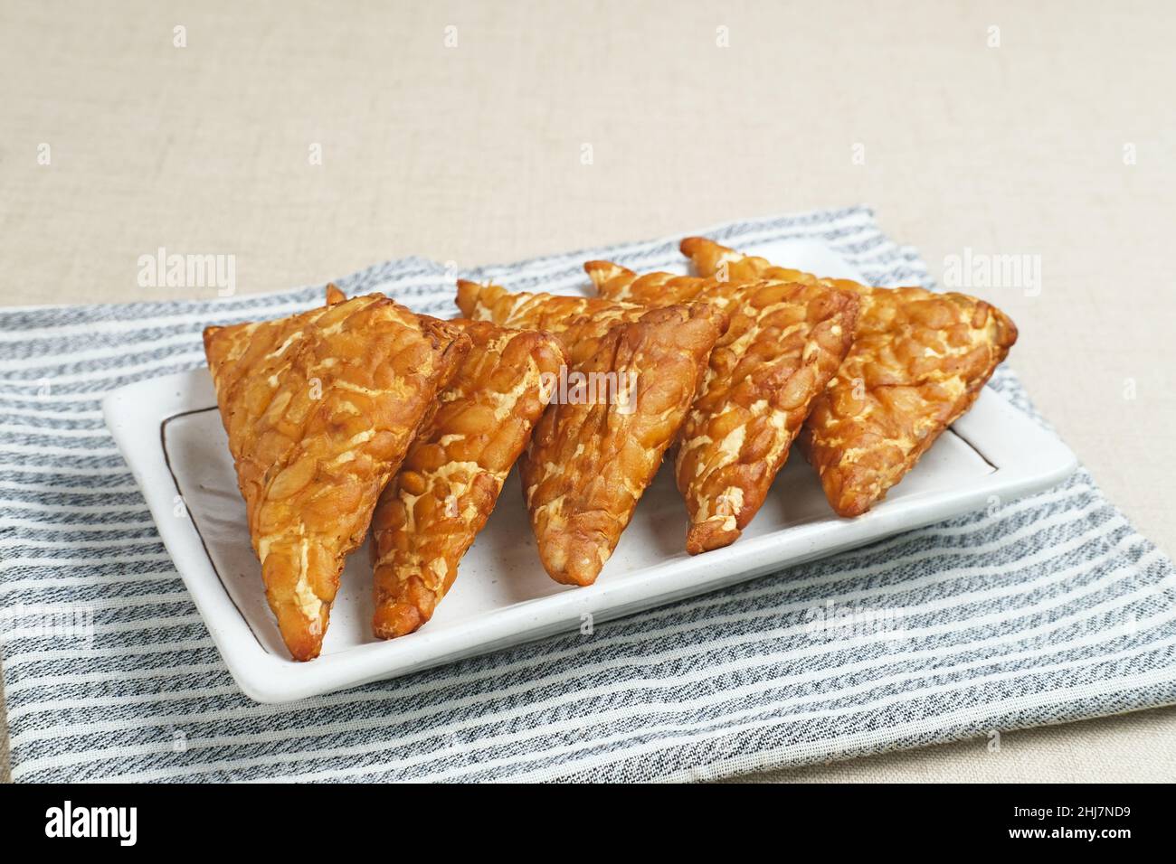 Tempeh, Tempe Goreng oder Fried Tempeh ist ein traditionelles indonesisches Essen, das aus fermentierten Sojabohnensamen hergestellt wird. Stockfoto