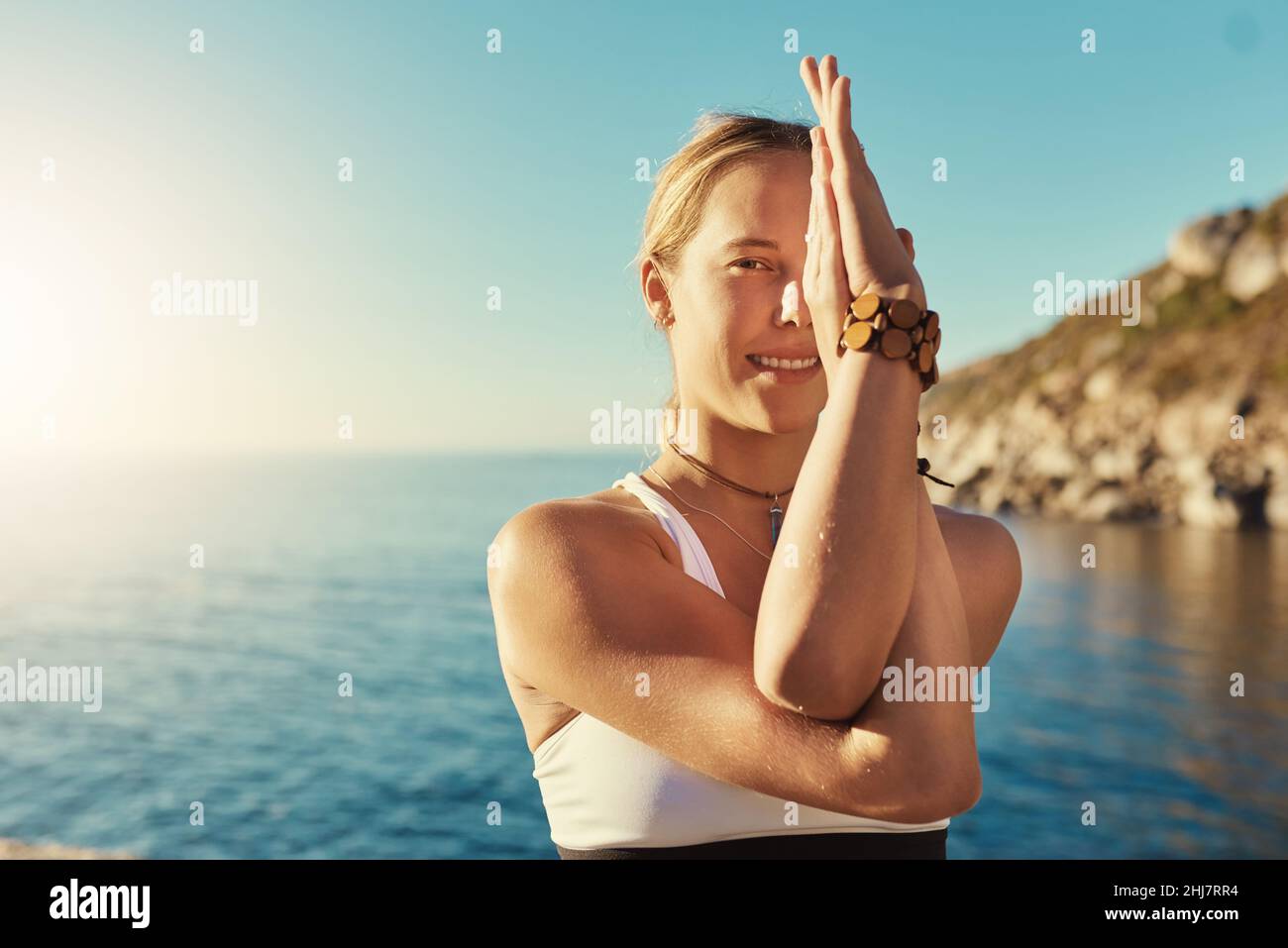 Yoga ist für jeden von Vorteil. Aufnahme einer jungen Frau, die am Strand Yoga macht. Stockfoto