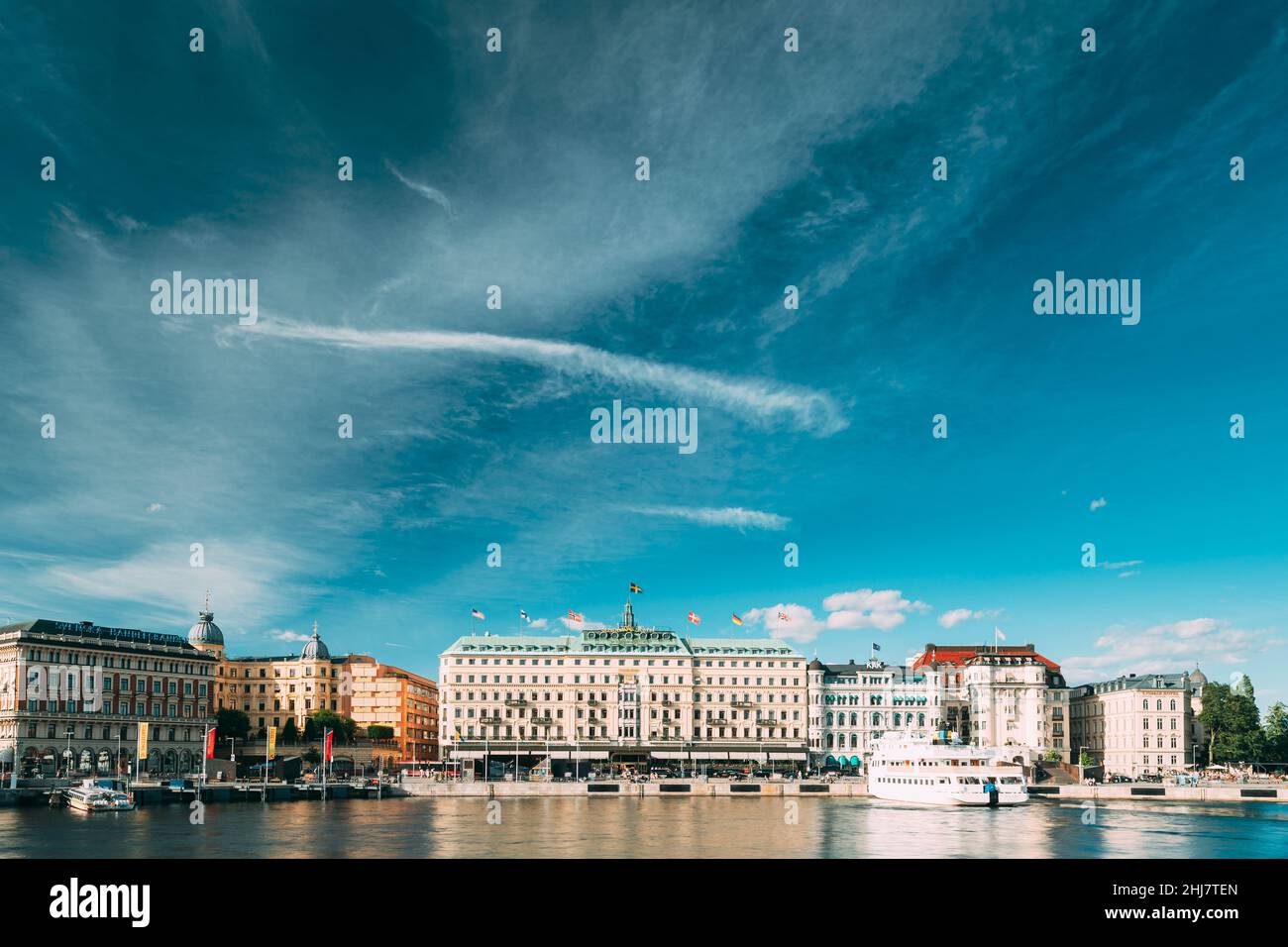 Stockholm, Schweden. Grand Hotel Auf Der Halbinsel Blasieholmen. Touristische Vergnügungsboote, Die In Der Nähe Des Berühmten Grand Hotel Im Sonnigen Sommertag Schweben. Stockfoto