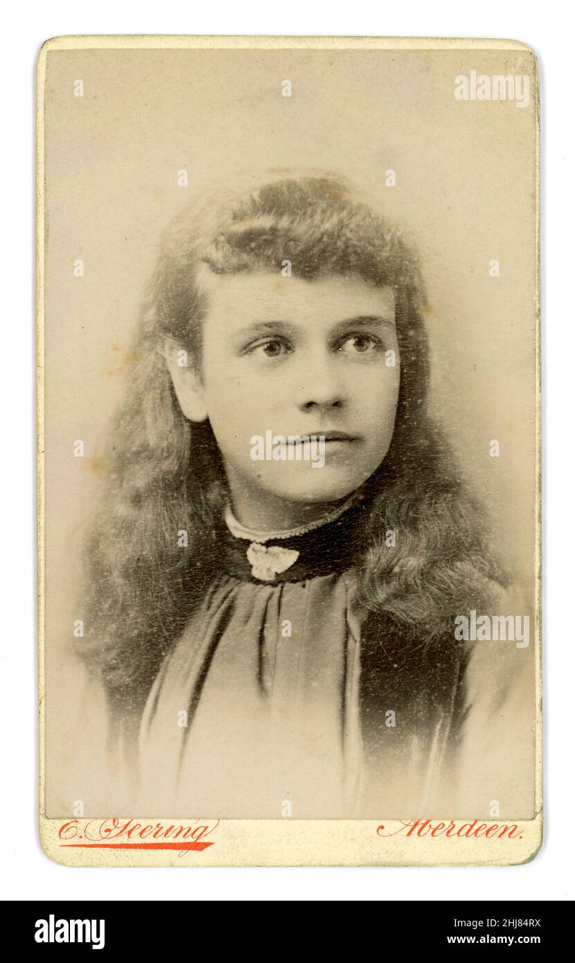 Original viktorianische Epoche Carte de Visite (CDV) eines hübschen schottischen Teenager-Mädchens mit langen Haaren, Brosche am Ausschnitt der Bluse, aus dem Fotostudio von E. Geering, Aberdeen, Schottland, Großbritannien um 1885. Stockfoto