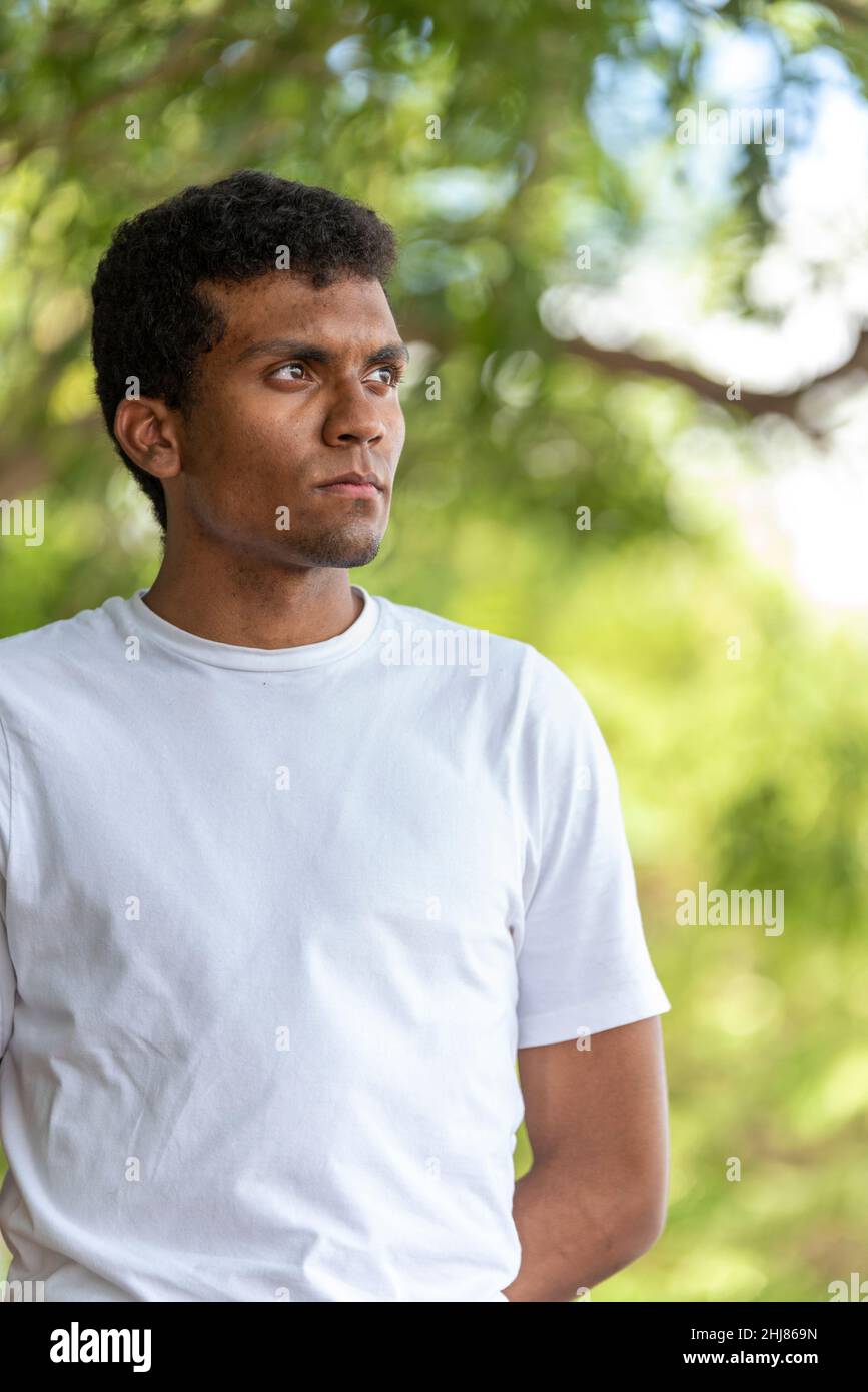 Porträt eines selbstbewussten jungen Latino-Mannes mit T-Shirt in einem öffentlichen Park. Stockfoto