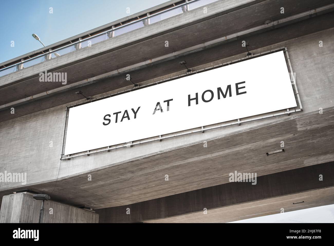 Plakatwand mit „zu Hause bleiben“-Worten auf der Brücke Stockfoto