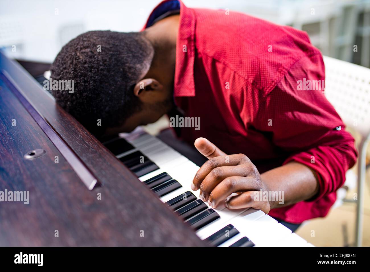 Verärgert afroamerikanischen schönen Musiker Mann unzufrieden singen, und Unterricht auf Klavier zu spielen Stockfoto
