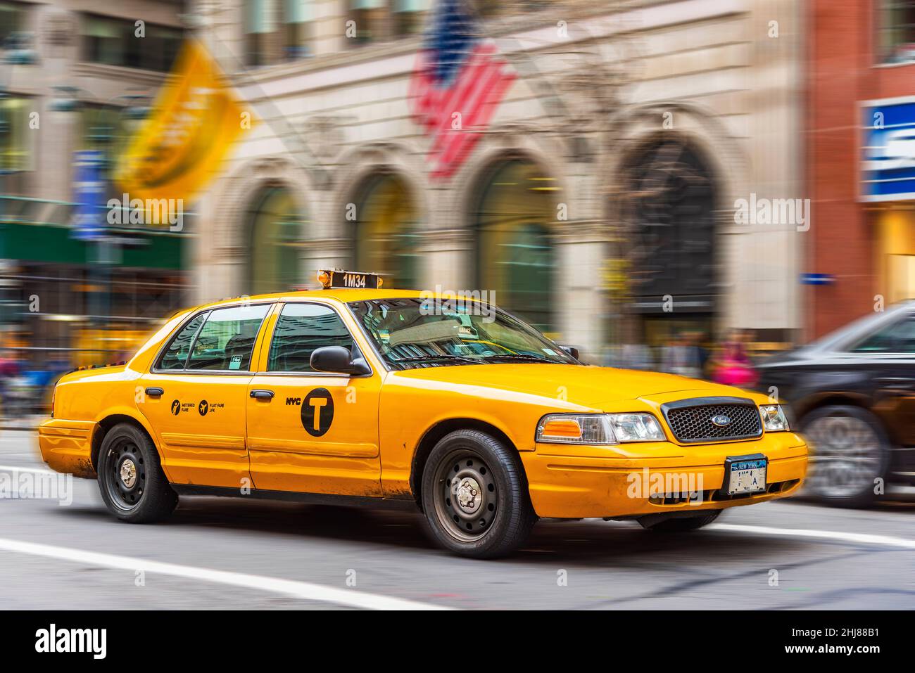 Gelbes Taxi mit Bewegungsunschärfe auf der Fifth Avenue, Manhattan, New York, USA Stockfoto