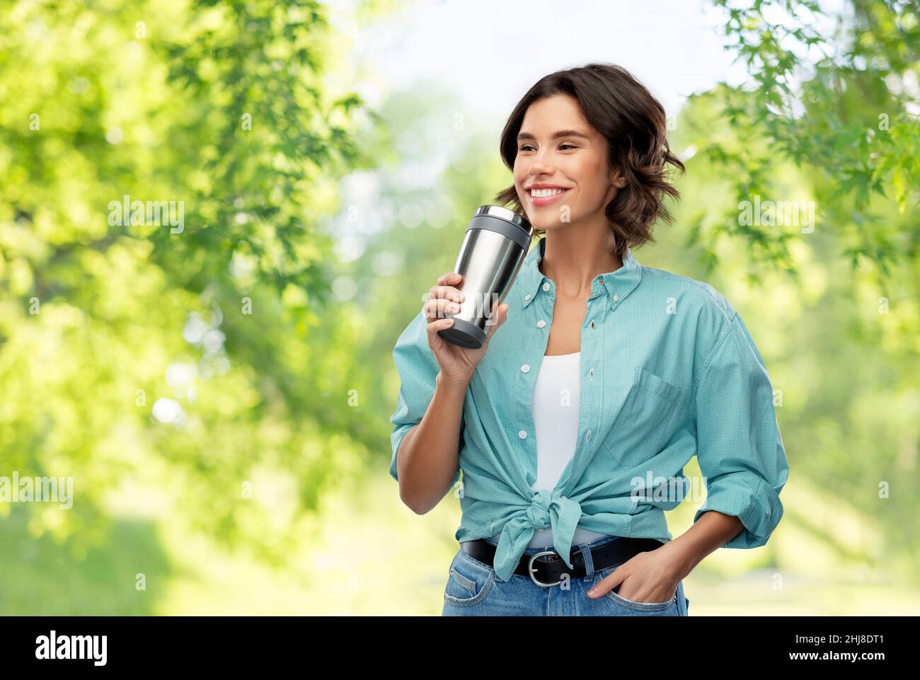 Frau, die aus einem Thermobecher oder Becher trinkt Stockfoto