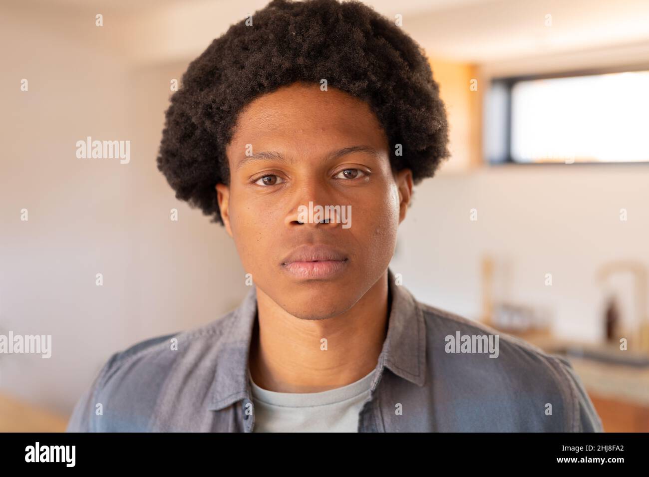 Nahaufnahme Porträt von selbstbewussten afroamerikanischen jungen Mann mit Afro-Frisur. Unverändert, Lebensstil, Freizeitaktivitäten, Frisur und häusliches Leben con Stockfoto