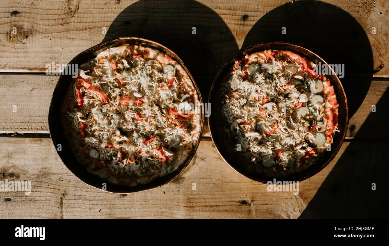 Blick aus der Ferne auf hausgemachte Pizza auf dem Tisch, hausgemachte Pizza Stockfoto