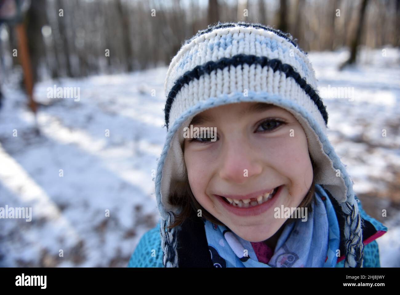 Kind lächelt und macht eine Grimasse, die ihren fehlenden Milchzahn zeigt Stockfoto
