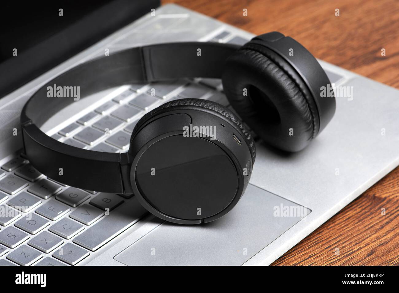 Schwarzer kabelloser Kopfhörer auf der Computertastatur Stockfoto