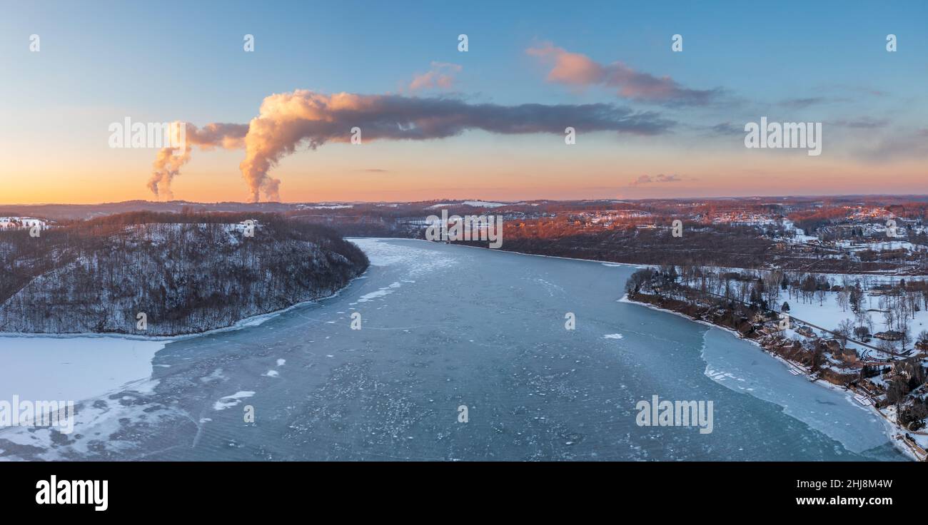 Luftdrohnen-Sonnenuntergangspanorama des frzoen und schneebedeckten Cheat Lake und der Kraftwerke in der Nähe von Morgantown, West Virginia Stockfoto