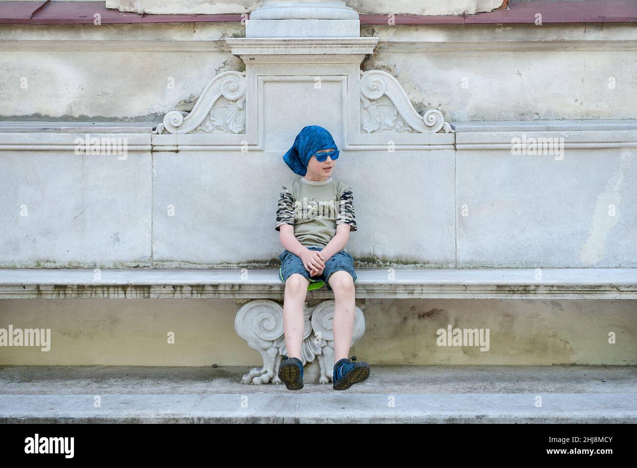 Junge auf einer Bank vor dem Palast in Tułowice, Woiwodschaft Opole, Polen Stockfoto
