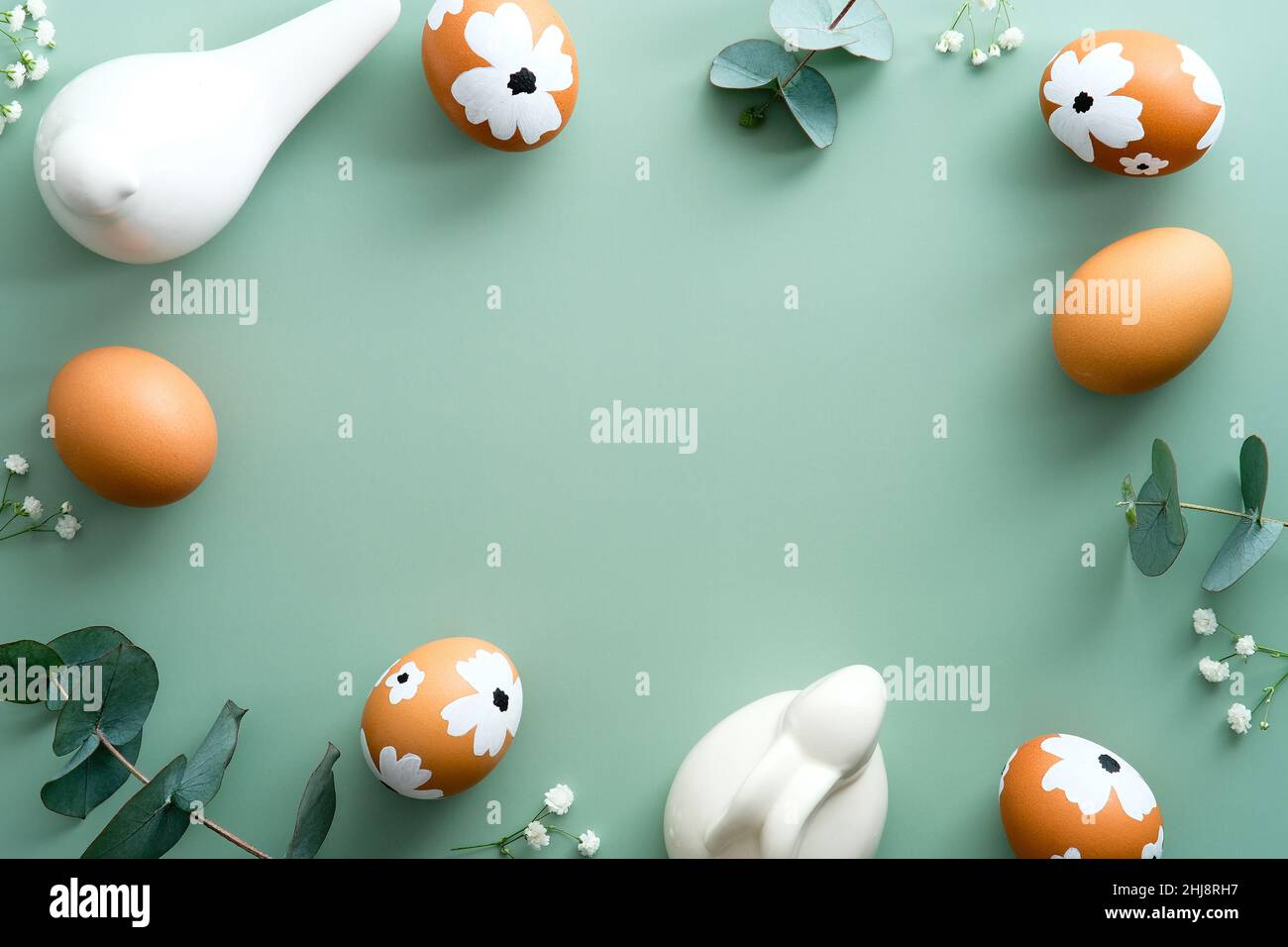 Fröhliches Osterkartendesign. Elegant bemalte Ostereier mit Dekorationen auf pastellgrünem Hintergrund. Flach liegend, Draufsicht, Kopierbereich Stockfoto