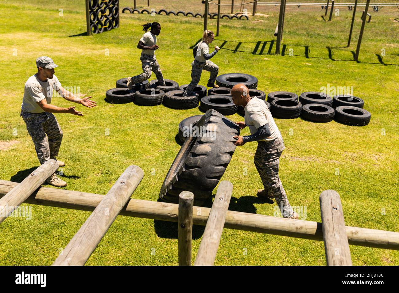 afroamerikanischer Soldat, der während eines Hinderniskurses im Bootcamp einen Reifen umdreht Stockfoto