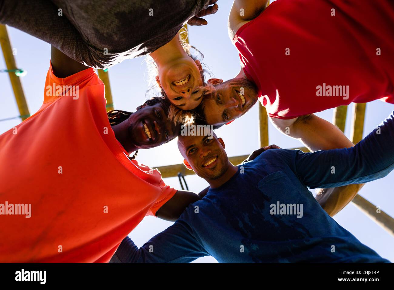 Low-Angle-Ansicht der Gruppe von verschiedenen männlichen und weiblichen fit Menschen bilden Huddle im Boot Camp Stockfoto