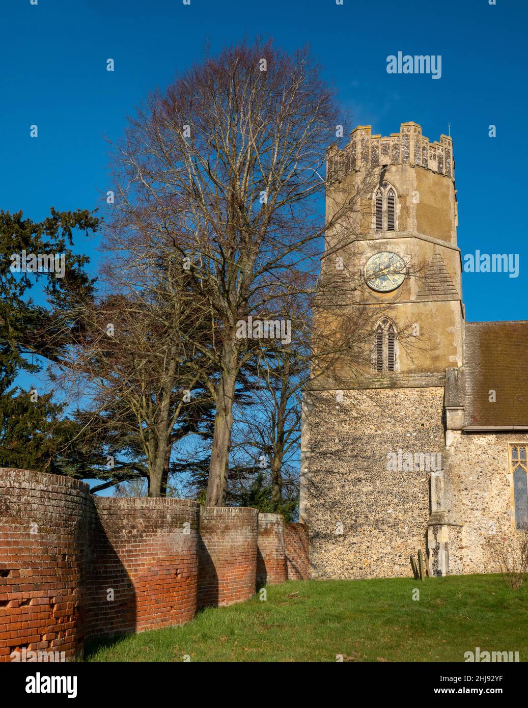 Achteckiger Turm und Ziffernblatt sowie ein Teil der krinkligen Kurbelwand, All Saints Church Easton, Suffolk, Großbritannien Stockfoto