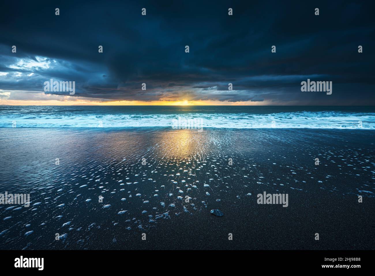 Stürmische Meereswellen und Schaum nach einem Gewitter bei Sonnenuntergang. Strand Marina di Cecina, Tyrrhenisches Meer, Toskana, Italien, Europa. Stockfoto
