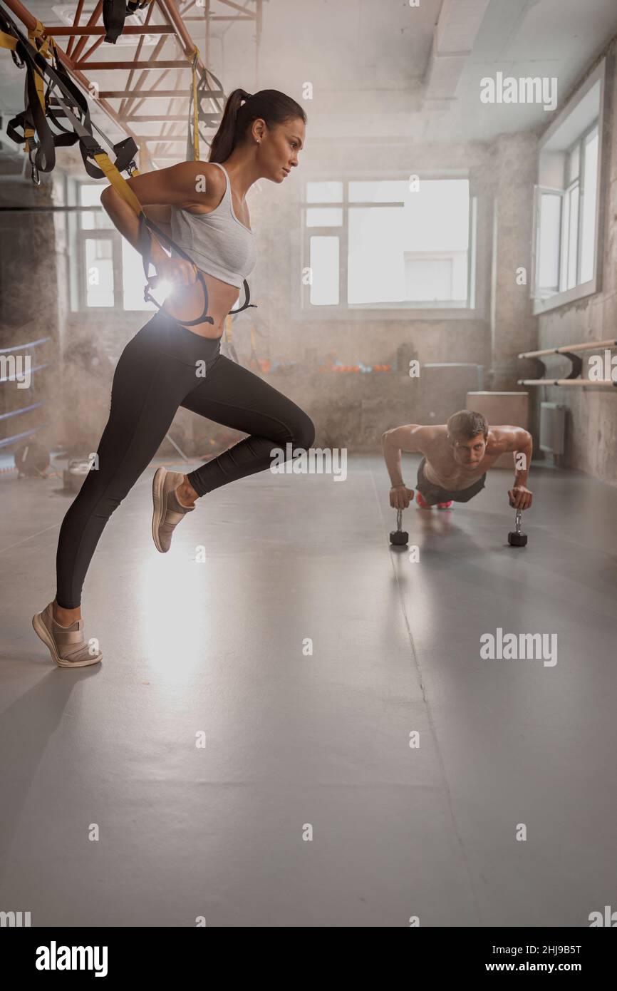 Attraktive junge Frau, die im Fitnessstudio fit wird Stockfoto