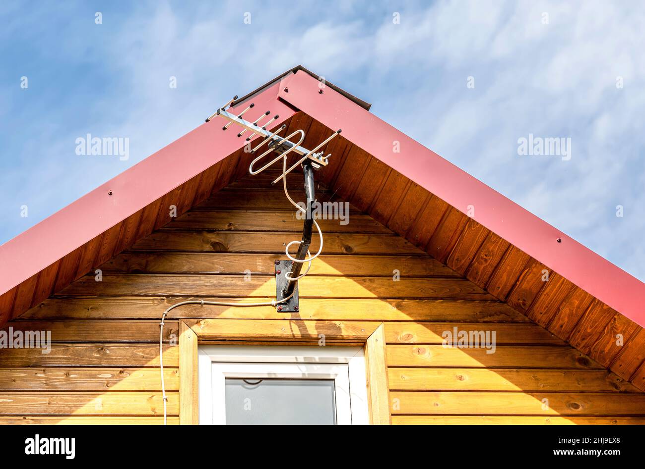 Antenne auf dem Dach eines alten Holzhauses gegen den Himmel Stockfoto