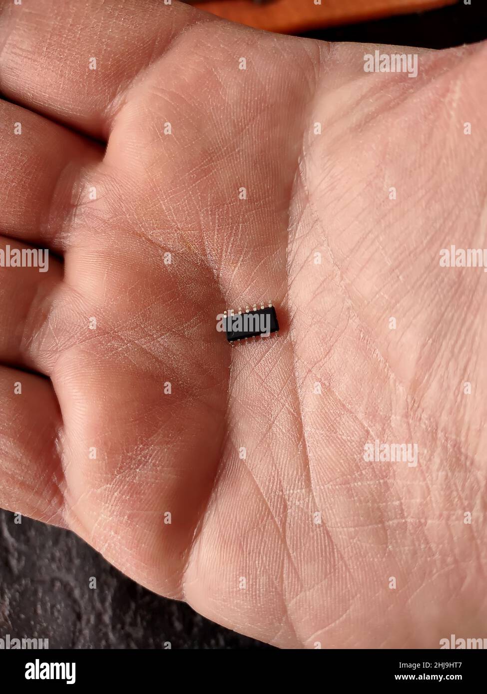 Menschliche Hand mit elektronischem smd-Chip in der Mitte Stockfoto