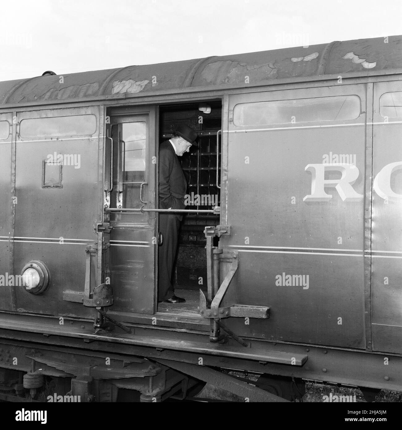 1963 der große Eisenbahnraub war der Raub von ¿Millionen 2,6 von einem Royal Mail-Zug, der von Glasgow nach London auf der West Coast Main Line in den frühen Morgenstunden des 8th. August 1963 an der Bridego Railway Bridge, Ledburn, in der Nähe von Mentmore in Buckinghamshire, England, fuhr. Unser Bild Zeigt ... Detective Superintendent Gerald McArthur von Scotland Yard (trägt Hut) untersucht den Postwagen auf dem Abstellgleis am Bahnhof Cheddington, Freitag, 9th. August 1963. Stockfoto