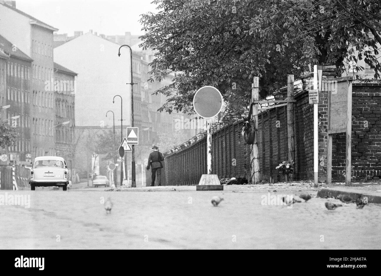 Szenen in Berlin, drei Jahre nach Beginn der Arbeiten am Bau der Berliner Mauer, die Ost und West trennt. Sicherheitskräfte patrouillieren an der Wand entlang. 25th. Oktober 1964. Stockfoto