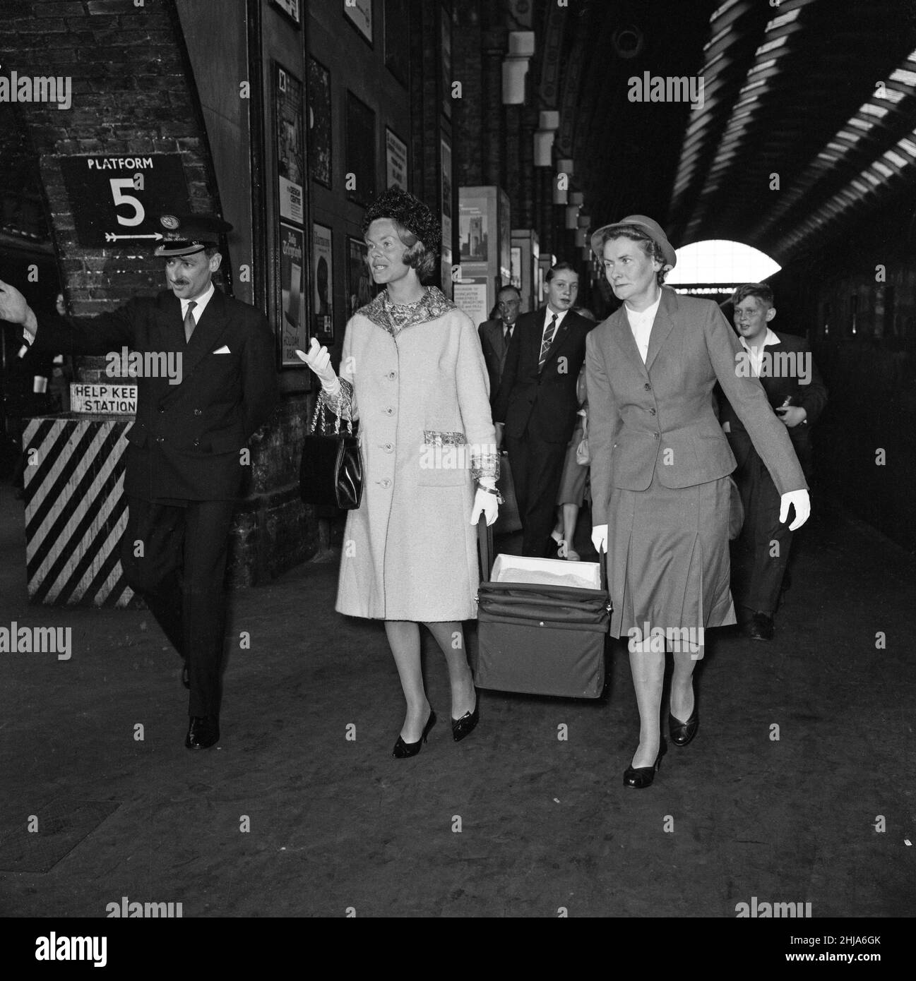 Katharine, Herzogin von Kent, die ihr Baby in einem Kinderbett mit Hilfe der Krankenschwester trug, verließ den Zug von York am Kings Cross, fast unbemerkt von der Menge der Reisenden auf dem Bahnsteig. 30th. August 1962. Stockfoto