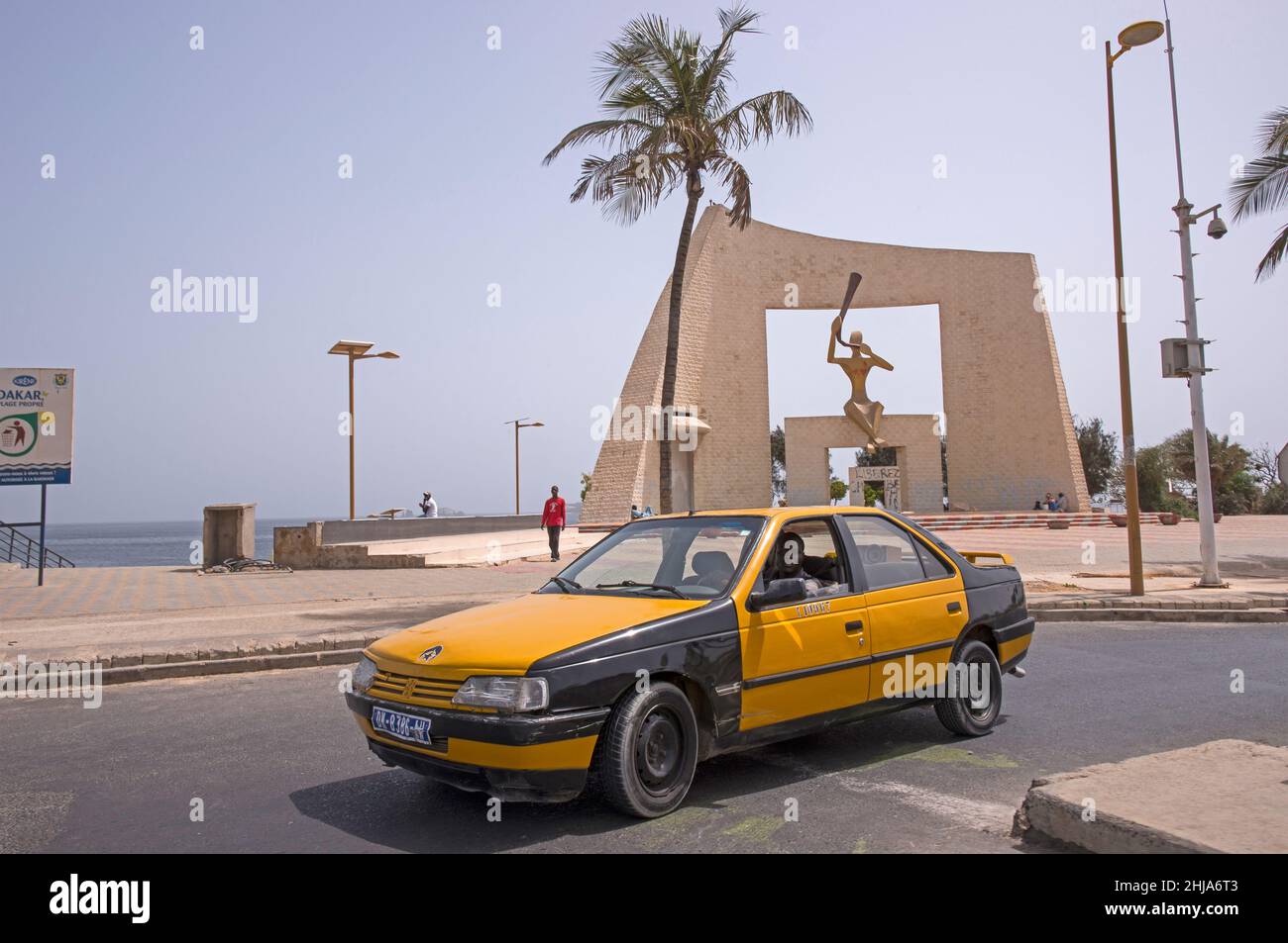 Taxifahrt neben dem Millennium-Denkmal an der Küste von Dakar, Senegal Stockfoto