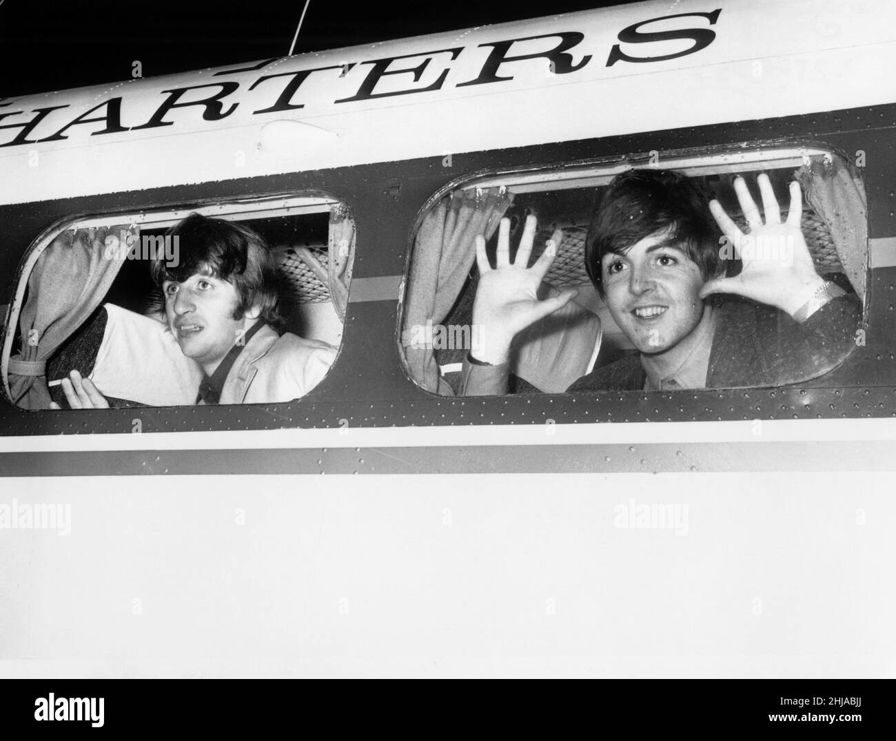 Die Beatle-Mitglieder Ringo Starr (links) und Paul McCartney schauen aus dem Flugzeugfenster am Blackpool Airport, um auf dem Weg zur TV-Show "Blackpool Night Out" zu sein.19. Juli 1964 Stockfoto