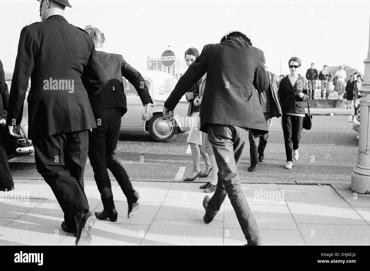 Mods gegen Rockers. Bild zeigt die Szene in Margate, North East Kent im Mai 1964. Ein Jugendlicher wird von der Polizei in Handschellen gelegt und weggebracht. Foto vom 17th. Mai 1964 Stockfoto