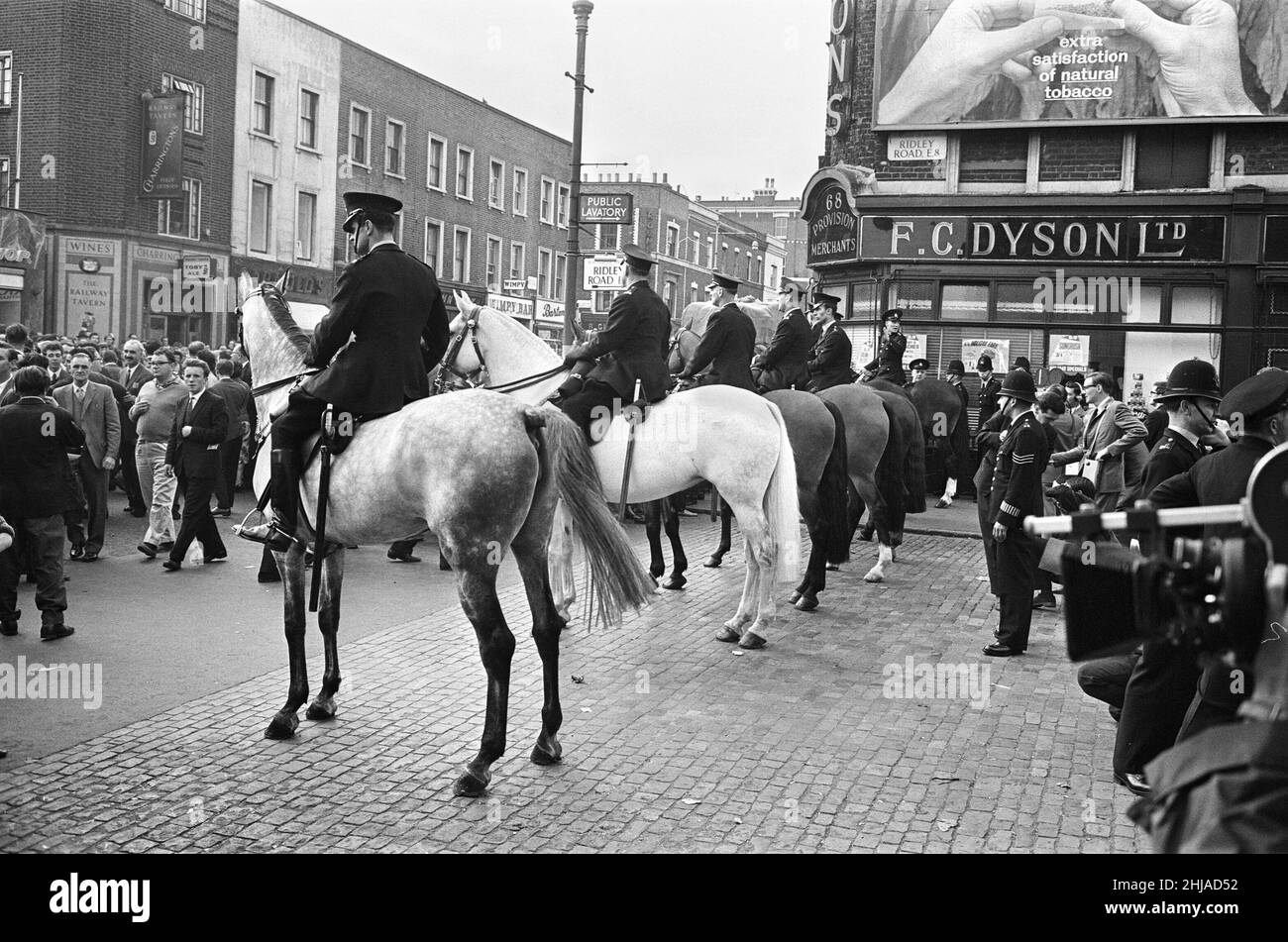 Eine große Menge versammelte sich in der Ridley Road, E8, um gegen den ehemaligen faschistischen Führer Sir Oswald Mosley und Mitglieder seiner antisemitischen Blackshirt-Gruppe zu demonstrieren, die eine Kundgebung im Londoner East End geplant hatten. Mosley und seine Gruppe wurden angegriffen und zu Boden geschlagen, sobald sein Treffen in der Ridley Road, Dalston, eröffnet wurde. Die Polizei schloss das Treffen innerhalb der ersten drei Minuten ab und verhaftete 54 Personen, darunter Sir Oswalds Sohn Max. Die Polizei auf dem Pferderücken versucht, einige der riesigen Menschenmengen zu kontrollieren. 31st. Juli 1962. Stockfoto