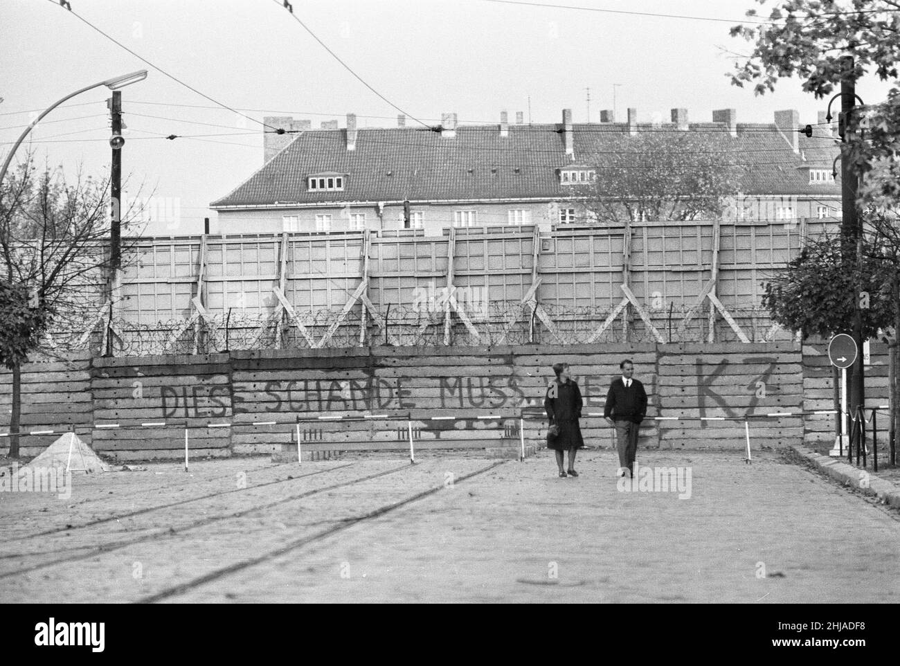 Szenen in Berlin, drei Jahre nach Beginn der Arbeiten am Bau der Berliner Mauer, die Ost und West voneinander trennt.West-Berliner Bürger schlendern eine Straße in der Nähe der Berliner Mauer entlang. Aufgenommen am 25th. Oktober 1964. Stockfoto