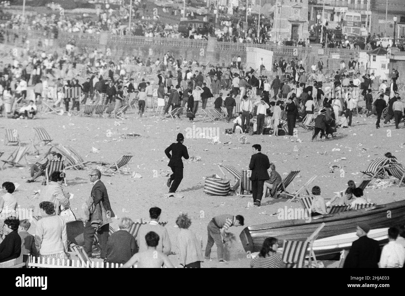 Mods gegen Rockers. Bild zeigt die Szene in Margate, North East Kent im Mai 1964. Die Polizei läuft rüber zu den Mods und Rockers, um zu versuchen, die Unruhestifter zu beruhigen. Bild aufgenommen am 17th. Mai 1964 Stockfoto
