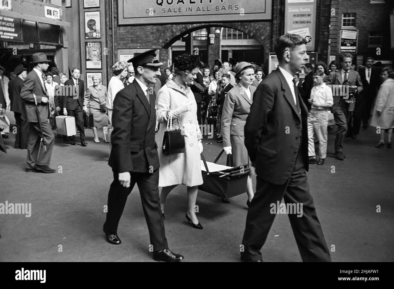 Katharine, Herzogin von Kent, die ihr Baby in einem Kinderbett mit Hilfe der Krankenschwester trug, verließ den Zug von York am Kings Cross, fast unbemerkt von der Menge der Reisenden auf dem Bahnsteig. 30th. August 1962. Stockfoto