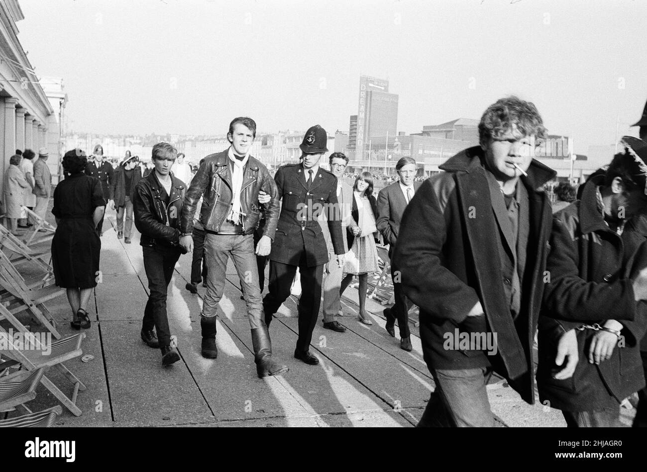 Mods gegen Rockers. Bild zeigt die Szene in Margate, North East Kent im Mai 1964. Ein Jugendlicher wird von der Polizei in Handschellen gelegt und weggebracht. Foto vom 17th. Mai 1964 Stockfoto