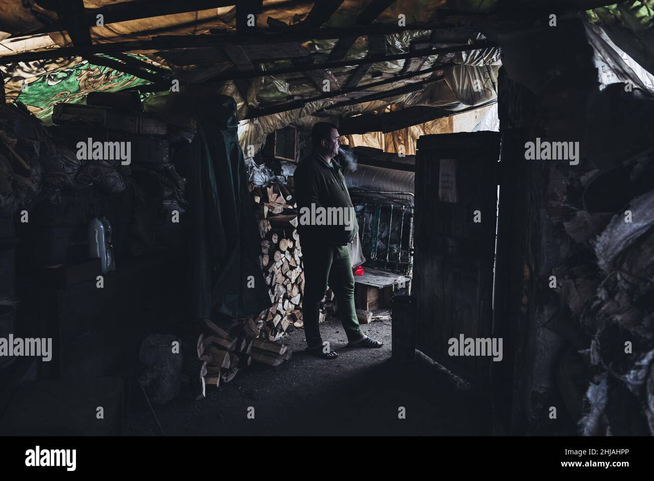 Ein Soldat raucht an seiner Militärposition in Avdivka. Seit 2014 findet in der Ostukraine in den Oblast Donezk und Lugansk ein Krieg statt. Dieses Gebiet steht im Streit zwischen ukrainischen Truppen und prorussischen Rebellen. Stockfoto
