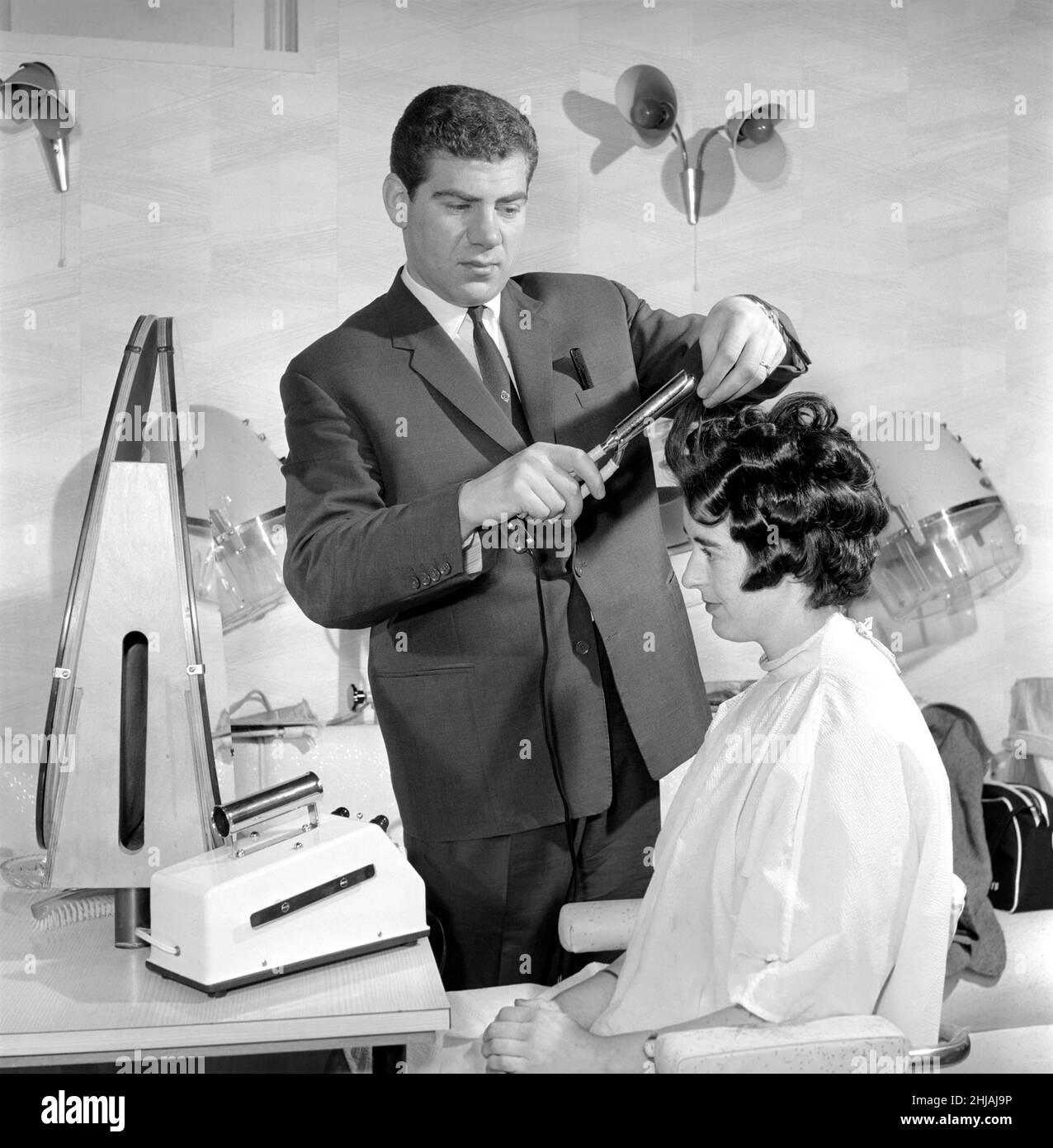 Frau hat bei den Friseuren die Haare geschnitten und gewellt, 7th. Juni 1962 Stockfoto