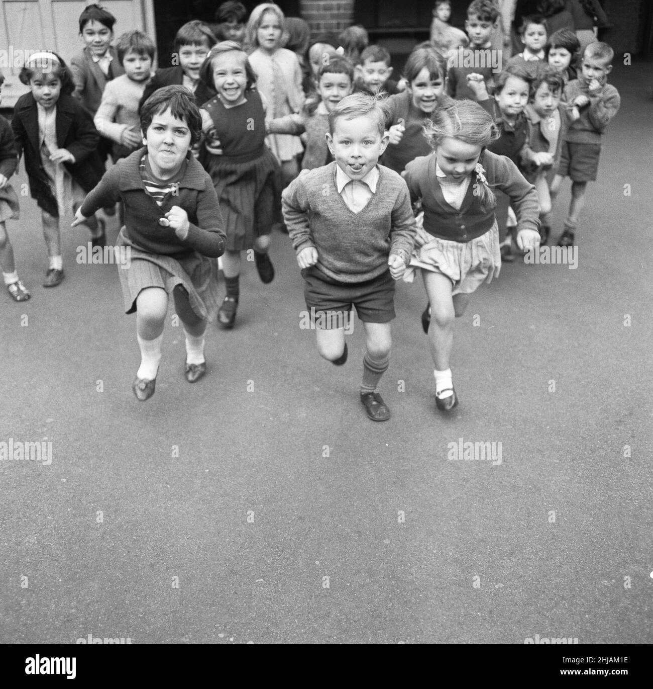 Nach einem Morgen mit Mathematik und Englisch können die Schüler von Christopher Hatton Primary nicht bis zur Pause für eine kleine Übung warten. 15th. November 1962 Stockfoto