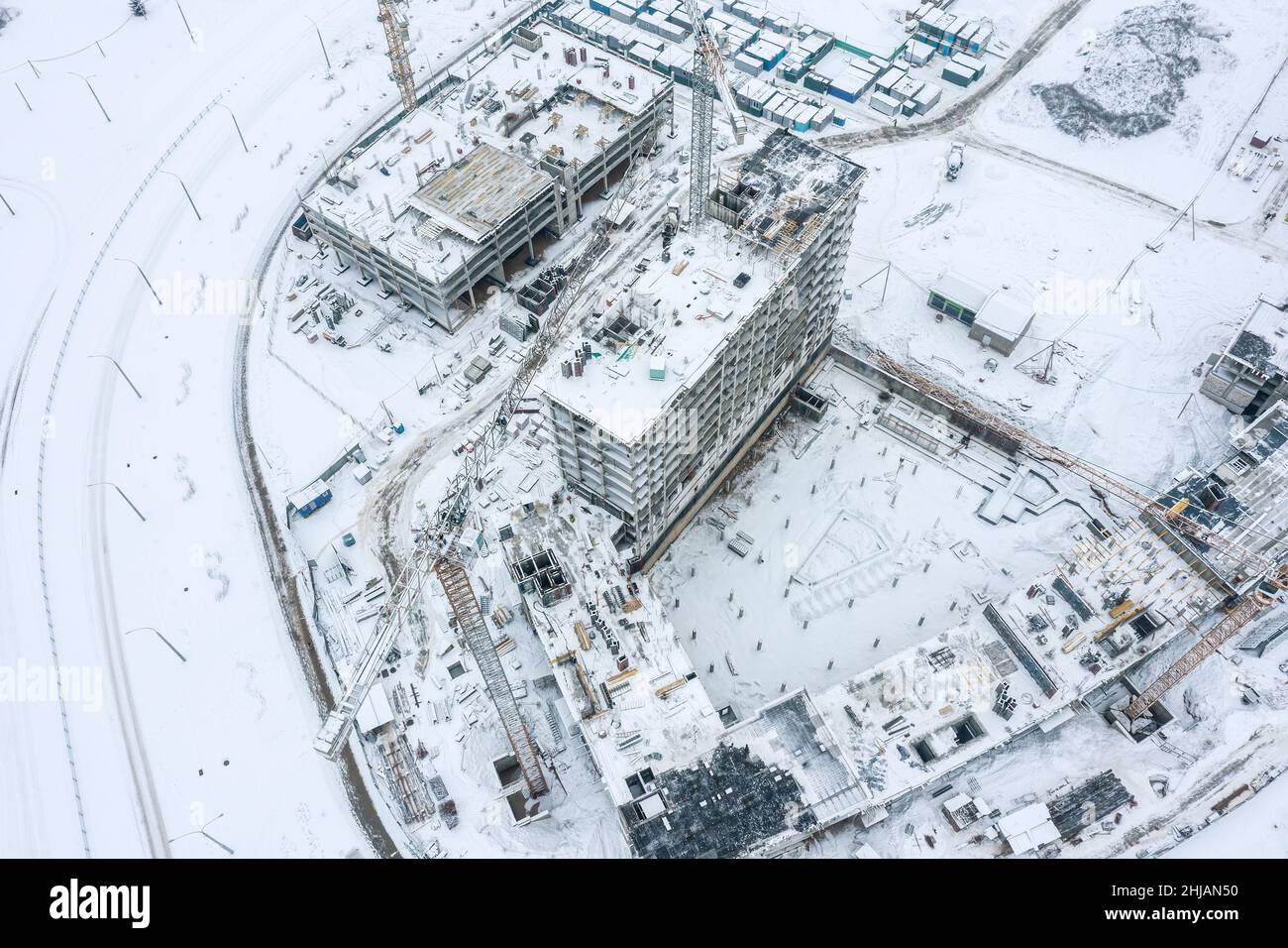 Moderne Wohnanlage im Bau. Turmdrehkrane bei der Arbeit. Winteransicht. Stockfoto