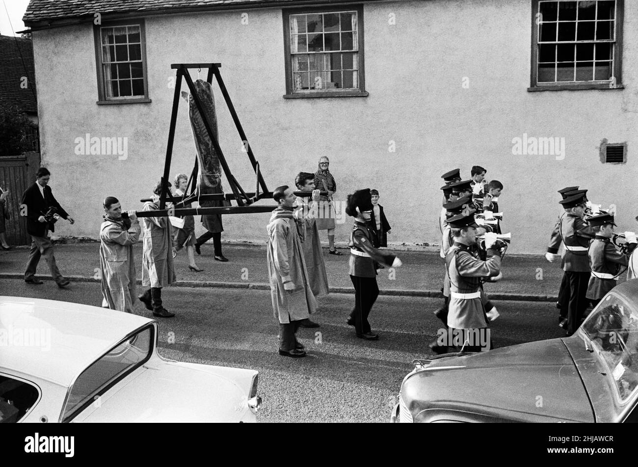 Dunmow Flitch Prozession durch die Straßen von Dunmow, Essex. Dunmow hält ein vierjähriges Ritual der "Flitch-Prozesse" ab, bei dem Paare eine Jury aus sechs lokalen Junggesellen und sechs lokalen Jungfrauen davon überzeugen müssen, dass sie sich ein Jahr und einen Tag lang nie unvermählt gewünscht haben. Wenn das Paar erfolgreich ist, werden sie entlang der High Street geführt und erhalten eine Schinkenspeckflatsch. 11th. Juli 1963. Stockfoto