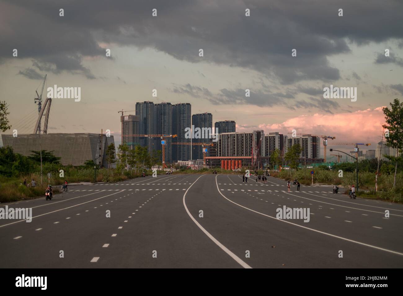 Menschen joggen auf der breiten Allee in einer großen Stadt. Wolkenkratzer im Hintergrund. Sonnenuntergang in der Metropole. Wunderschöner Himmel. Hochwertige Fotos Stockfoto