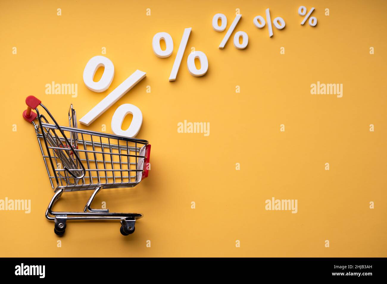 Verkaufsprozentsätze, Die Auf Gelbem Hintergrund In Den Warenkorb Fallen Stockfoto