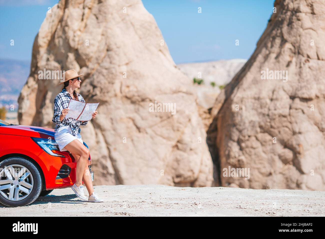 Junge schöne Frau mit Karte im Urlaub mit dem Auto Stockfoto